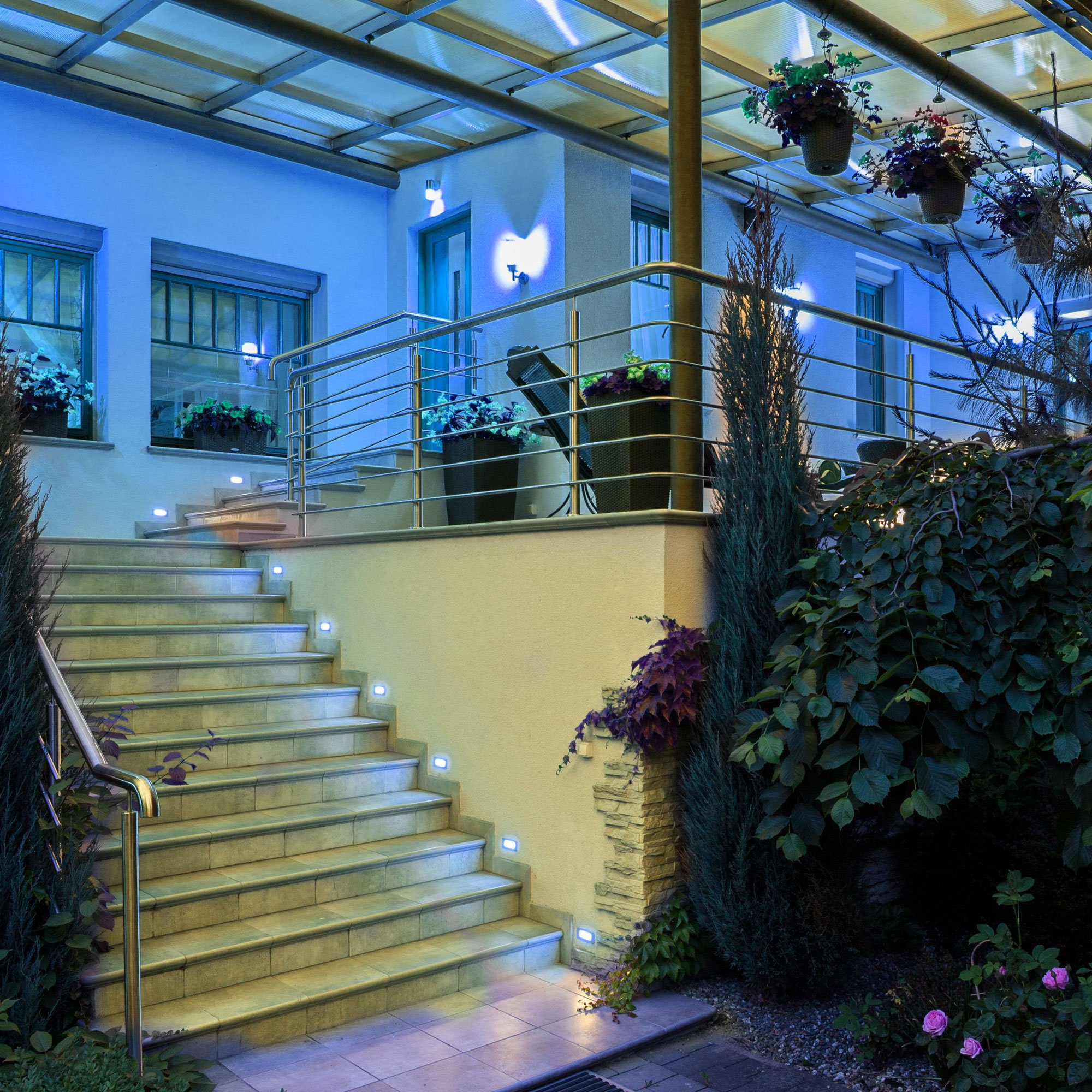alt="Iluminación decorativa azul en jardín y escalera con bombilla LED MATEL PAR38 instalada en zona exterior"